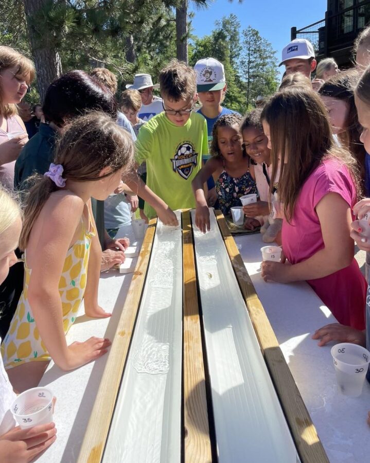 Kids gathered around for a minnow race activity.